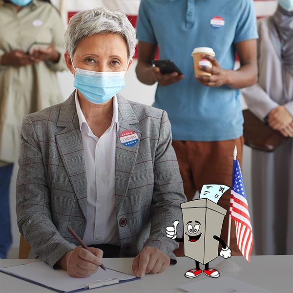 Poll worker at election polling place wearing a mask. In front of her is a cartoon of a ballot box character giving a "thumbs up" sign.